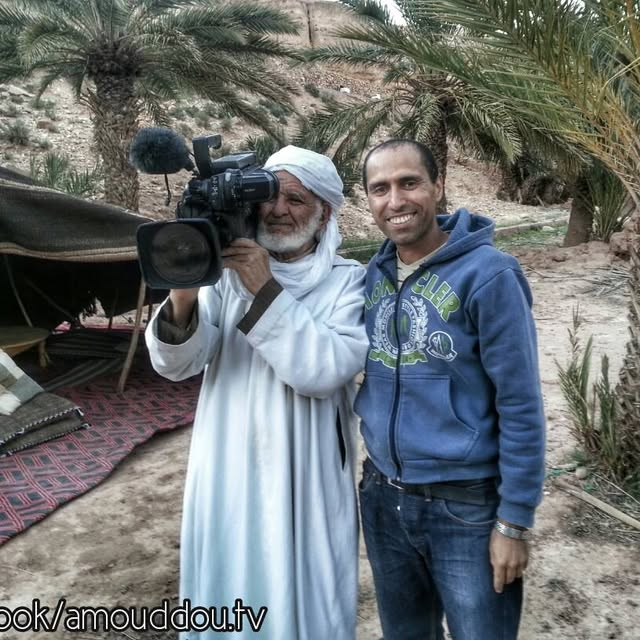 رجل مسن يحمل كاميرا أثناء تصوير أمودّو
